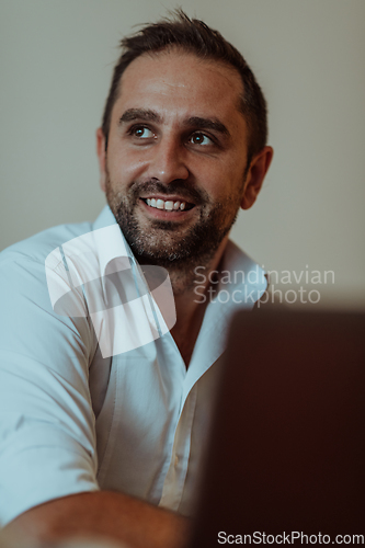 Image of A successful businessman is sitting in his office after a hard day's work