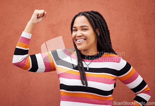 Image of Flexing, smile and portrait of a strong black woman for empowerment isolated in studio brown background. Confident, excited and young fashion, style and female model proud to be African American