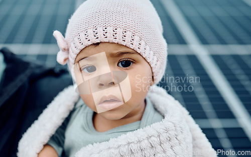 Image of Portrait, baby and beanie with a girl child in a blanket during winter looking cute or adorable. Children, babies and face with a small female kid feeling curious or serious while keeping warm