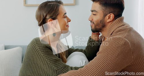 Image of Love, support and happy with a couple in their home together, sharing an intimate moment with a kiss. Smile, talking and romance with a young man and woman kissing on a sofa in the living room