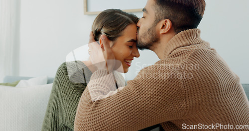 Image of Love, support and happy with a couple in their home together, sharing an intimate moment with a kiss. Smile, talking and romance with a young man and woman kissing on a sofa in the living room