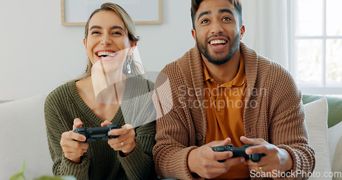 Image of Fun, playing and love with a gamer couple laughing, joking or bonding while gaming on a sofa in the living room of their home together. Game, funny and laugh with a man and woman enjoying video games