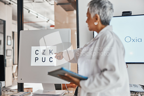 Image of Letter eye exam, chart and senior woman doctor pointing to eyes test and clinic assessment sign. Consulting, optometrist and tablet of a healthcare employee in a office for wellness and health