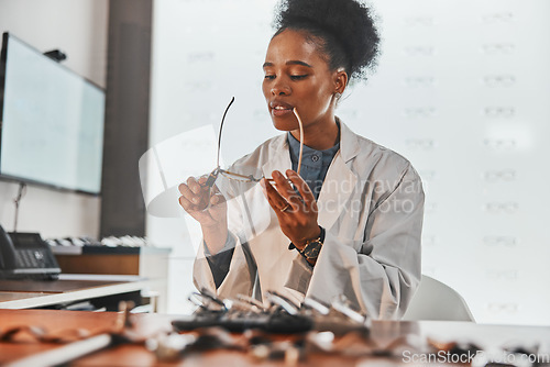 Image of Optometry, repair and optometrist fixing glasses for prescription frame in the optic clinic. Healthcare, vision and African female optician doing maintenance on eyewear or spectacles in optical store