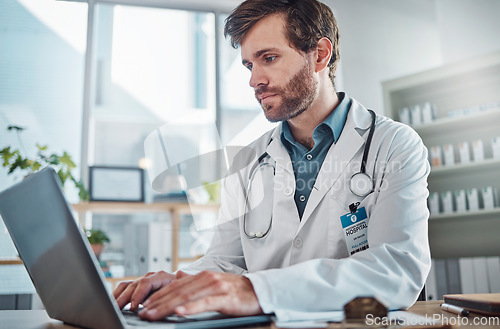 Image of Man, doctor and laptop typing in healthcare research, communication or social media at office desk. Male medical expert working on computer in online search, browsing or chatting on tablet at clinic