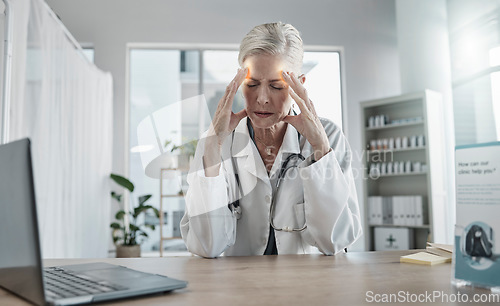 Image of Headache, stress and female doctor in her office with a laptop in the hospital after a consultation. Frustrated, burnout and senior woman healthcare worker working with a migraine in a medical clinic