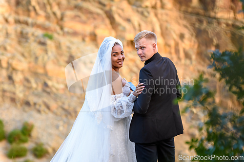 Image of Happy newlyweds turned around and looked into the frame