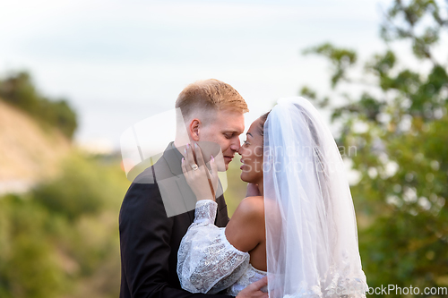 Image of Portrait of kissing newlyweds, close-up