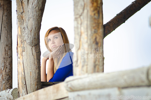 Image of Beautiful blonde woman in a blue dress in an old wooden building