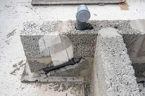 Image of Laying a sewer pipe in the bathroom wall during the construction of a house