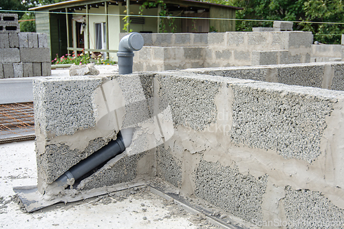 Image of Laying a sewer pipe in the wall during the construction of a house