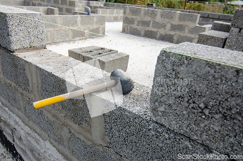 Image of A mallet lies on a part of a wall made of expanded clay concrete blocks during the construction of walls