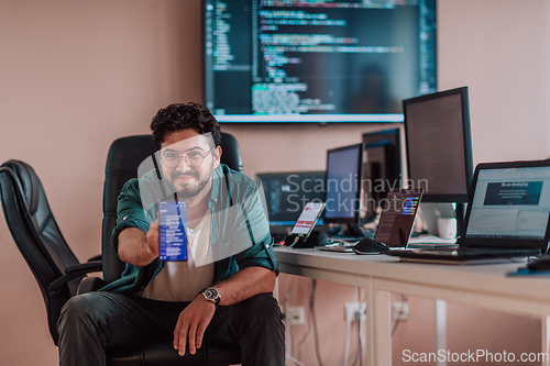 Image of A programmer diligently testing smartphone applications while sitting in their office.