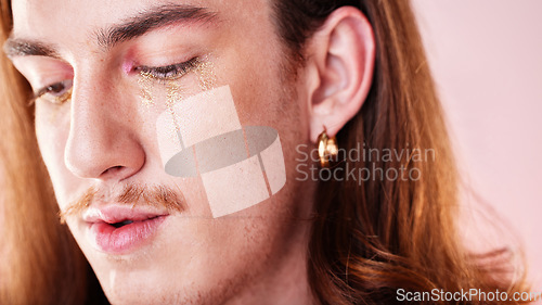 Image of LGBTQ, makeup and gay man in a studio with a cyberpunk, androgynous and natural aesthetic. Creative, cosmetics and young queer male model with a cosmetic, glow and beauty face by a pink background.