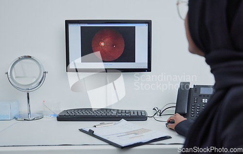 Image of Eye analysis, optometry and a doctor with a computer for research on a retina and lens problem. Ophthalmology, technology and Muslim woman looking at a monitor screen for eyesight and optic analytics