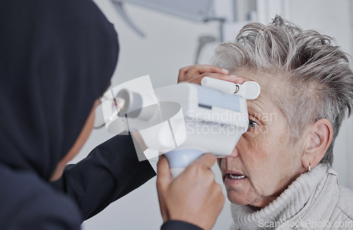 Image of Optometrist, eye test and senior woman patient in healthcare checkup for sight or vision at optometry clinic. Female optician checking eyes of elderly customer in examination for visual aid or help