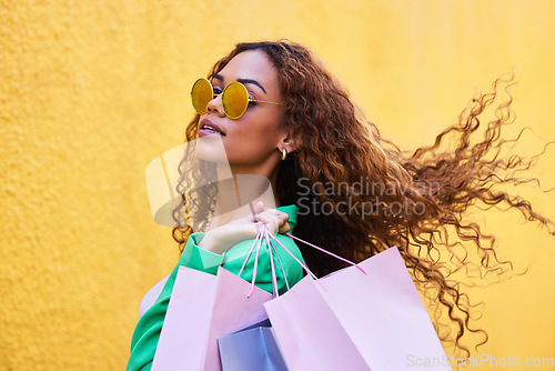 Image of Wealth, posh and portrait of a woman with shopping bags for fashion, luxury sale and discount. Elegant, retail and rich girl in the city to shop, buying clothes and fashionable clothing on a wall