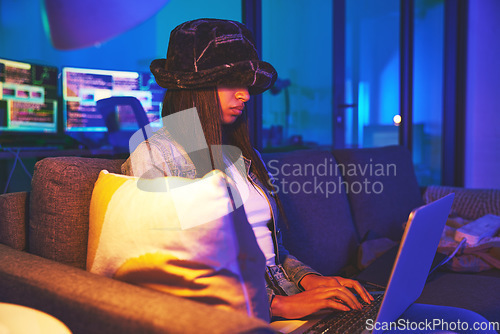 Image of Woman, hacker and programmer typing on laptop in home at night in neon to hack software. Cybersecurity sofa, ransomware phishing and female coder coding on computer for hacking database with malware.