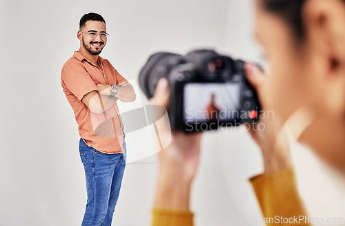 Image of Shooting, photography and photographer with man model in studio for creative, advertising and image. Media, backstage and professional woman videographer with guy, camera and equipment for photoshoot
