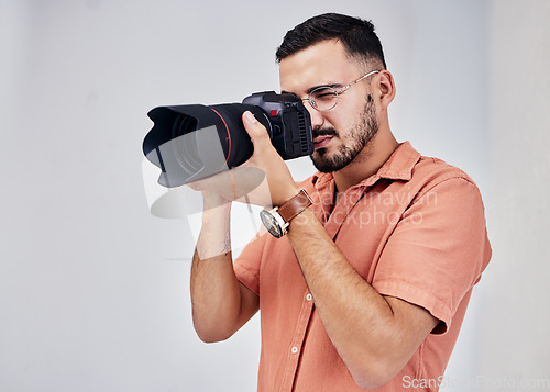 Image of Photographer, camera and art with a man in studio on a gray background for modern or creative photography. Media, production and photoshoot with a male photo professional or artist working backstage