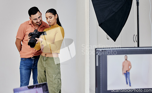 Image of Teamwork, photographer and startup people with camera in studio set for shoot, magazine project or online content. Planning, focus or girl examine picture for digital catalog or fashion web design