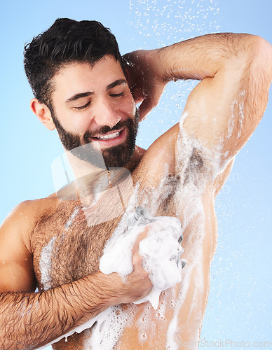 Image of Wellness, man and foam for cleaning, morning routine for hygiene, grooming and daily washing on blue studio background. Male, guy or drops of aqua, showering for freshness, luxury or soap on backdrop