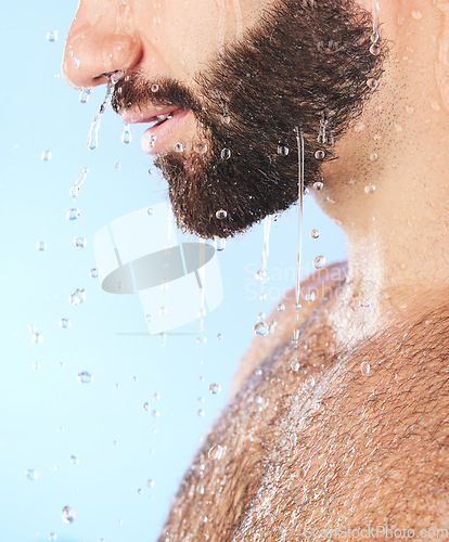 Image of Man face, shower and profile of a model in water for cleaning, skincare and hygiene wellness. Isolated, blue background and studio with young person in bathroom for dermatology and beard self care