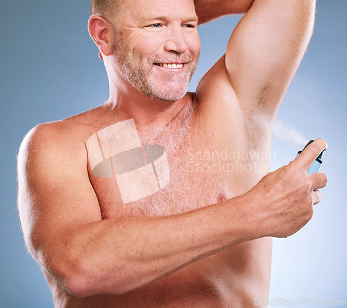 Image of Man, armpit and spray in skincare hygiene, grooming or smelling fresh against a studio background. Elderly male smiling and spraying deodorant under arms in satisfaction for aroma or clean cosmetics