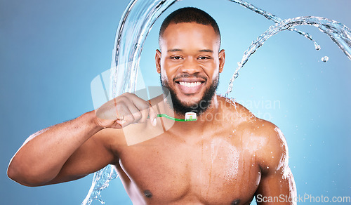 Image of Black man, face and toothbrush with water splash and dental, brushing teeth and hygiene on blue background. Cleaning, wet and grooming, male in portrait and smile for oral care product and toothpaste