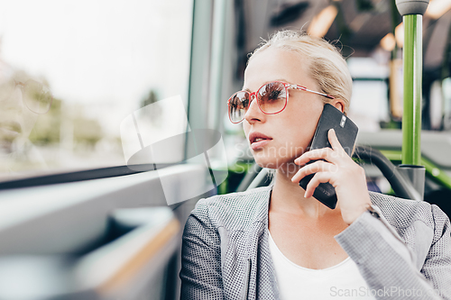 Image of Blonde business woman traveling by bus.