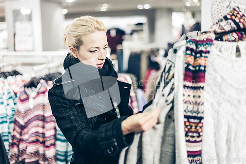 Image of Beautiful woman shopping in clothing store.