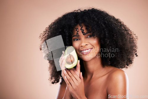 Image of Black woman, studio portrait and avocado for beauty, cosmetic skincare or health for wellness, smile or self care. Happy gen z model, african or fruit for natural aesthetic, healthy nutrition or diet