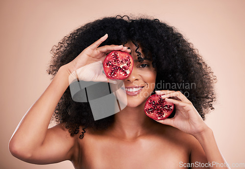 Image of Black woman, studio portrait and pomegranate for beauty, smile or skincare for health, wellness and glow by background. Happy gen z model, african or fruit for natural aesthetic, nutrition and diet