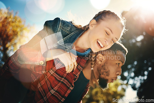 Image of Interracial couple piggyback in park, summer and outdoor date together in sunshine, happiness and nature. Happy man carrying woman in garden for young love, care and freedom to relax and smile