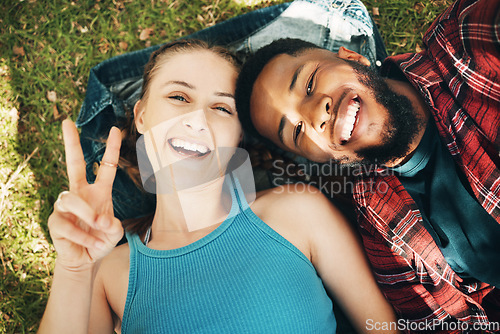 Image of Interracial couple, park and portrait selfie for lying, relax or grass for smile, love or happiness on holiday. Black man, woman or profile picture on lawn for social media for romance, above or care