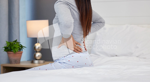 Image of Tired, feeling and pregnant woman with back pain on a bed for rest, injury and fatigue. Healthcare, stress and girl with backache during pregnancy in her bedroom with morning sickness and cramps