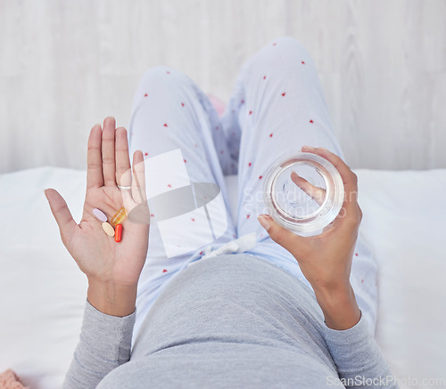 Image of Pills, water and woman hands for pregnancy health, growth and wellness. Pregnant person in home bedroom above glass and Pharma medicine supplement, nutrition and iron or magnesium for development