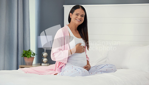 Image of Pregnant woman, portrait and stomach in home bedroom happy about bonding and growth. Mother to be person with hands on abdomen for healthy pregnancy development, body wellness and love or care on bed