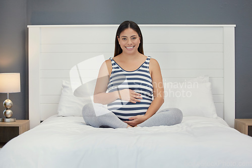 Image of Excited, motherhood and portrait of a pregnant woman on a bed for peace, rest and touching stomach. Smile, baby and girl feeling her belly during a pregnancy, maternity leave and relax in the bedroom