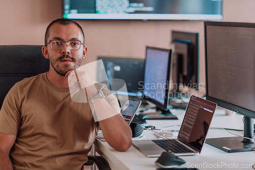 Image of A programmer diligently testing smartphone applications while sitting in their office.