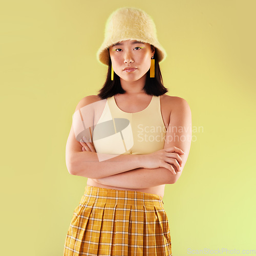 Image of Asian, woman in portrait and fashion with yellow aesthetic, beauty and confident with arms crossed on studio background. Style, edgy and female with streetwear, trendy designer clothes and mockup