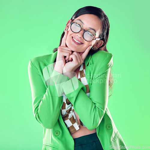 Image of Woman, smile and fingers on face by green background, studio and happy smile for career vision. Young model, retro aesthetic and ideas with glasses, vintage fashion, pride and happiness by backdrop