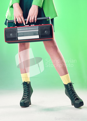 Image of Radio, woman and music with retro technology and fashion, entertainment with station, funk and legs on green background. Style, vintage sound and audio equipment, female boots with broadcast device