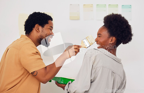 Image of Painting, funny or happy black couple in DIY, home renovation or house remodel together with a paintbrush. Playing, smile or crazy African man laughing with woman working or decorating with team work