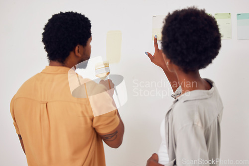 Image of Painting, wall or black couple in DIY, home renovation or house remodel together with a paintbrush. Back view, partnership or African man speaking to a woman working with team work or collaboration