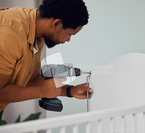 Image of Installation, drill and man building a crib while preparing for his new baby in the family home. Engineering, metal and African father doing maintenance or repairs on the bed in nursery at his house.