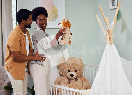 Image of Love, pregnancy and couple with teddy bear in the nursery with excitement while preparing for their baby. Happy, smile and young African man with his pregnant wife looking at toy together in bedroom.