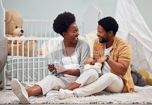 Image of Funny, laundry and black couple getting ready for a baby, folding clothes and preparation in pregnancy. Happy, parents and pregnant woman and man sitting with clothing for child and conversation