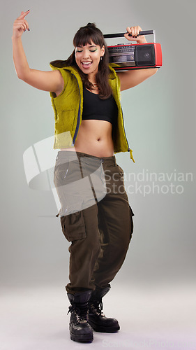 Image of Dance, vintage and woman with a radio for music isolated on grey studio background. Party, fashion and dancing girl holding a cassette stereo listening to audio, boombox record and track with rhythm