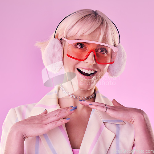 Image of Fashion, glasses and woman with smile on pink background for beauty, vaporwave style and cosmetics. Creative aesthetic, makeup and face of girl with earmuffs, gen z clothes and cyberpunk accessory